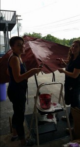 The Purple Painted Lady Patio Umbrella Primer Red In Process on loading dock